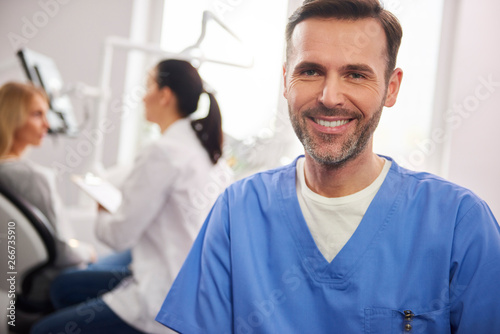 Front view of smiling male dentist in dentist's clinic