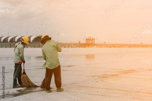 Two workers are using a broom. Clean the airport floor photo