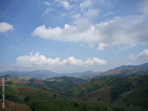 The wide landscape of the green valley, horizon and the blue sky with cloud