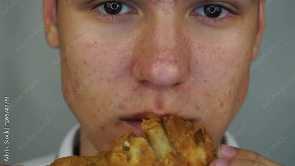 Boy is eating the big crispy chicken feet. Concept street food or fast food Boy is eating the big crispy chicken feet. Concept street food or fast food