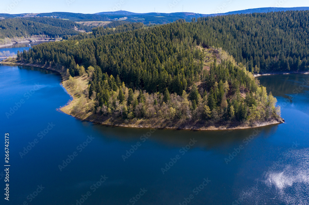 Aerial view of a flight over a reservoir in the Harz Mountains, a German low mountain range, with mountains and forests