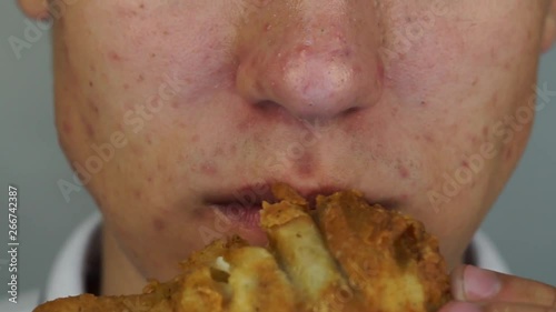 Man is eating the big crispy roast chicken feet. Concept street food or fast food