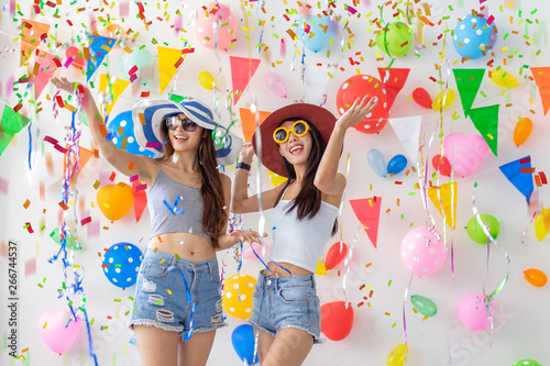 celebration new year or birthday party group of asian young woman and confetti happy,funny concept.drinking wine happy and fun in new year celebrate, color balloon background.