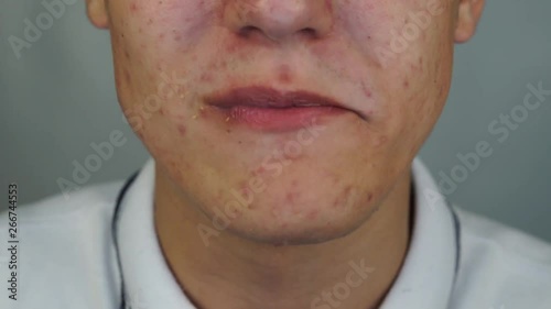 Young man is eating the crispy chicken feet and licks his lips after eating