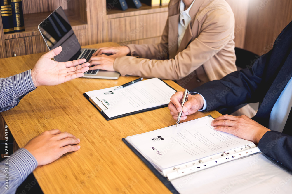 young man explaining about his profile to business managers sitting in job Interview. listen to candidate answers Hiring employee, nervously clutched scolded by boss. young man explaining about his profile to business managers sitting in job Interview. listen to candidate answers Hiring employee, nervously clutched scolded by boss.