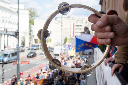 Fotografie, Obraz Right hand holding a tambourine over the street
