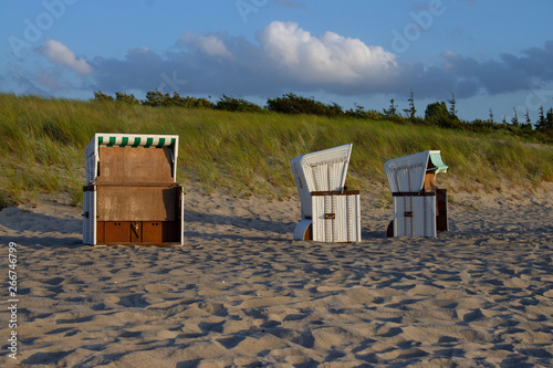 Drei Strandkörbe am Sandstrand vorm Deich photo