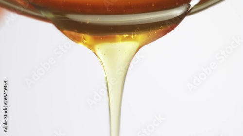 Honey pouring into glass bowl