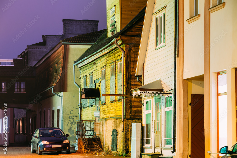Fototapeta premium Parnu, Estonia. Night View Of Old Wooden Houses At Hospidali Street In Evening Night Illuminations