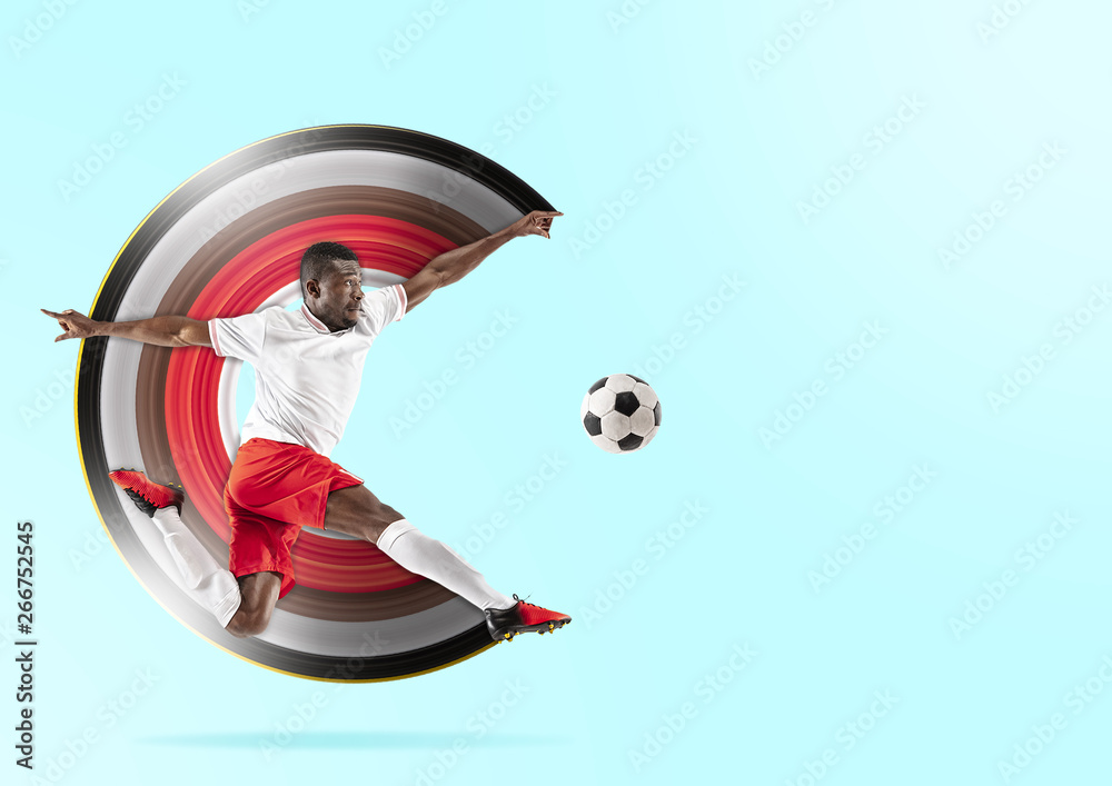 Professional african american football or soccer player in motion isolated on blue studio background. Fit jumping man in action, jump, play, excitement at game. Abstract design, movement concept. Professional african american football or soccer player in motion isolated on blue studio background. Fit jumping man in action, jump, play, excitement at game. Abstract design, movement concept.