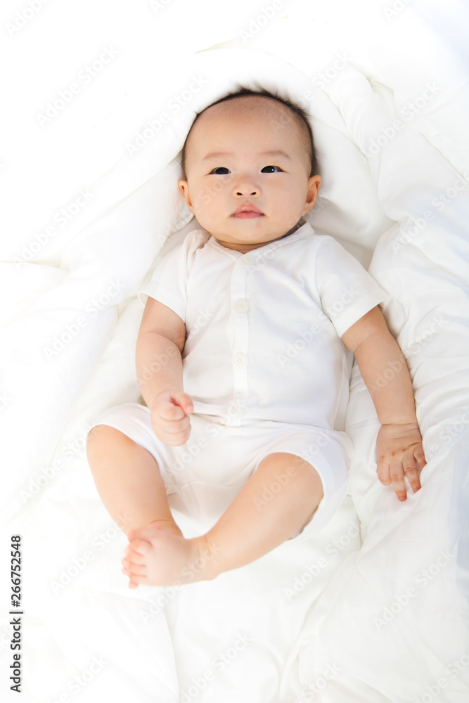 Asian baby happy in the room.Asian baby girl lying down on bed . Asian baby happy in the room.Asian baby girl lying down on bed .