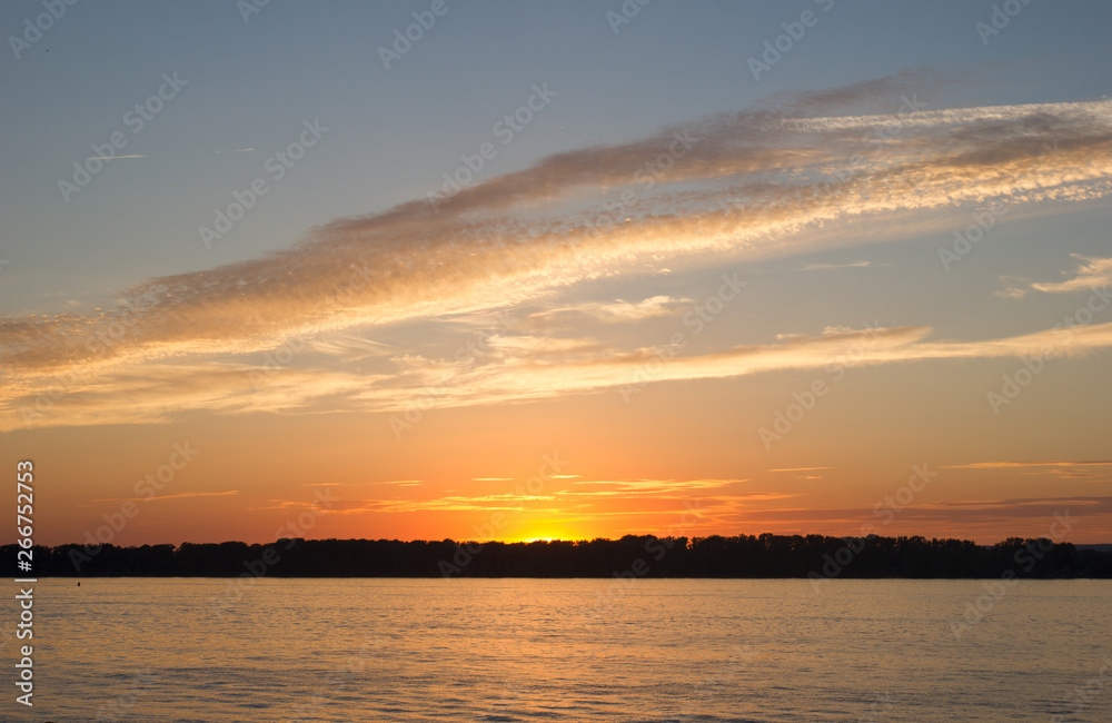 Sunset sky over the blackened forest and the river Volga opposite the city of Samara, Russia