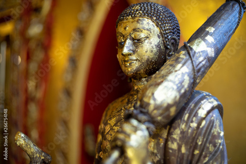 Golden buddish state walking and holding umbrella in the art style at watbangpleeyainai temple  Samutprakan  Thailand