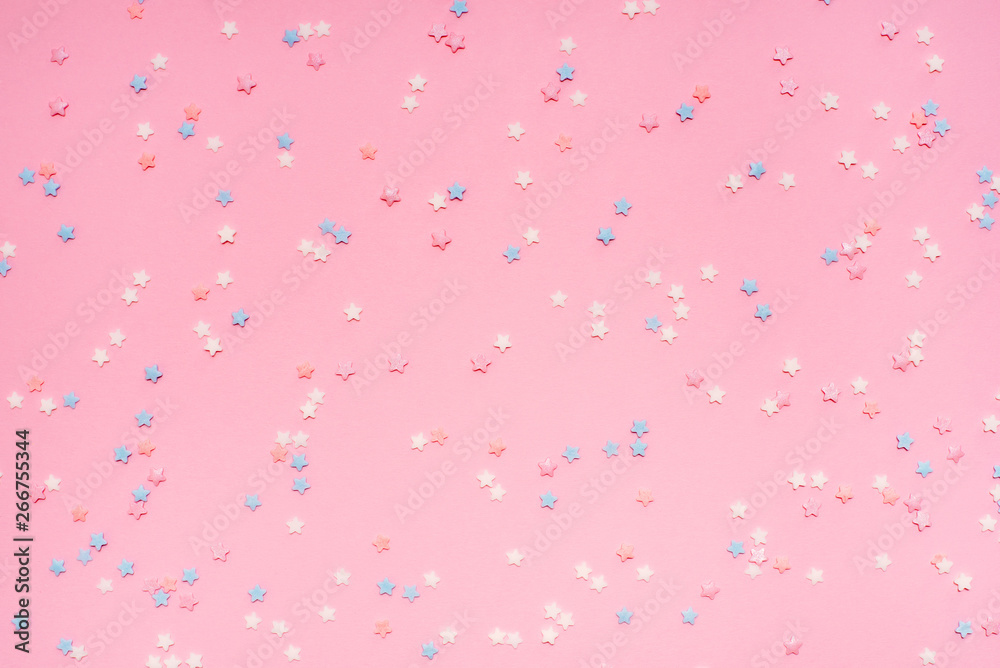 Little stars confetti on pink background. Holyday concept.