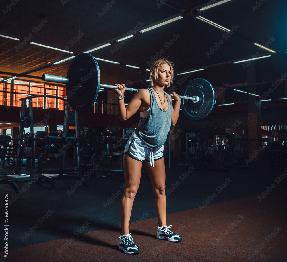 Strong Athletic Woman in Sportswear Lifts Heavy Barbell and Does Squats  with it as a Part of Her Fitness. classic bodybuilding. hardcore doing  exercise by fitness girl Stock Photo | Adobe Stock