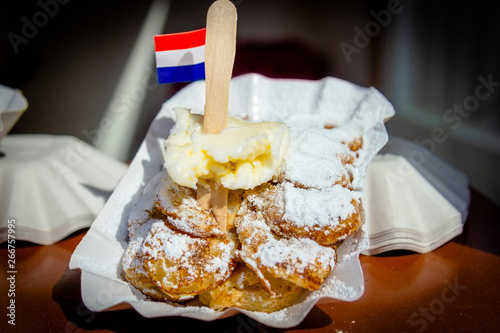 A plate with fresh baked Poffertjes with banana. Poffertjes are a traditional Dutch batter treat