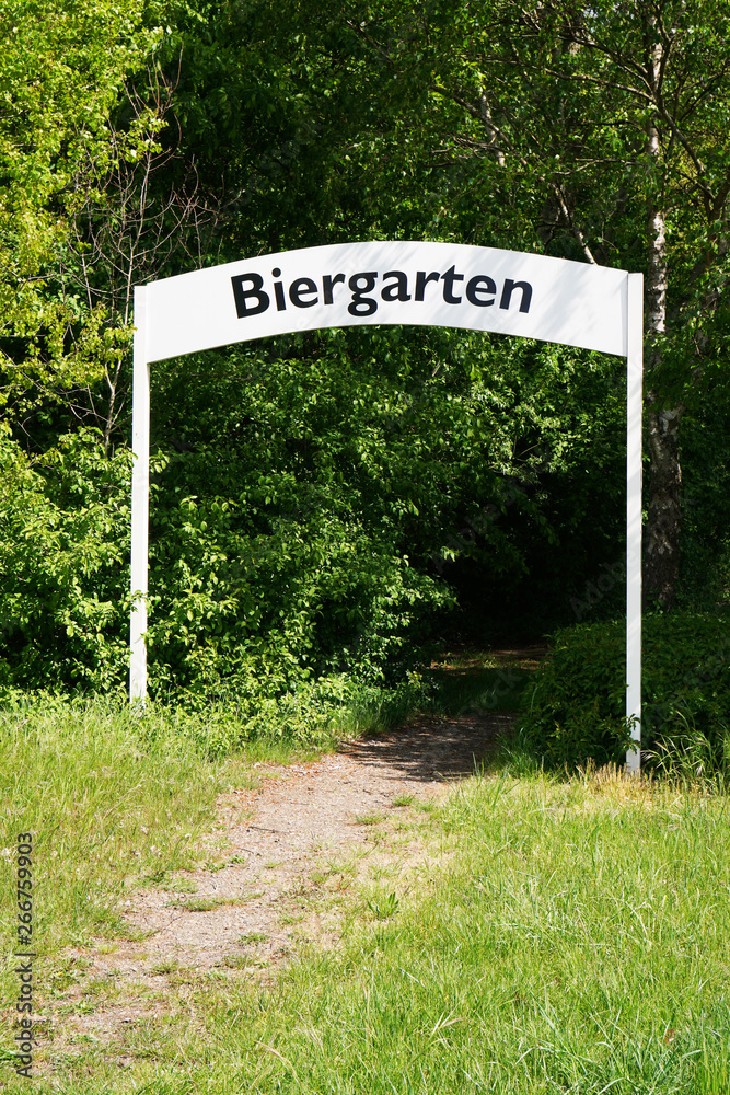 biergarten or beer garden in Germany - path leading through entry arch gate amidst trees biergarten or beer garden in Germany - path leading through entry arch gate amidst trees