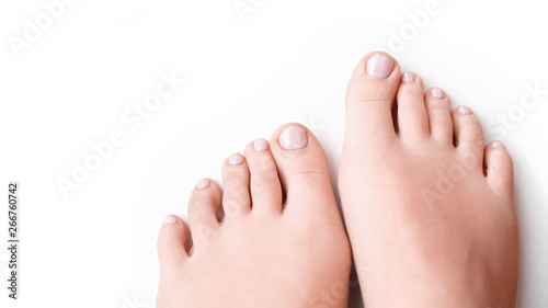 Woman feet with soft pink manicure isolated on white background