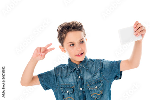 kid in denim shirt taking selfie and showing peace sign isolated on white