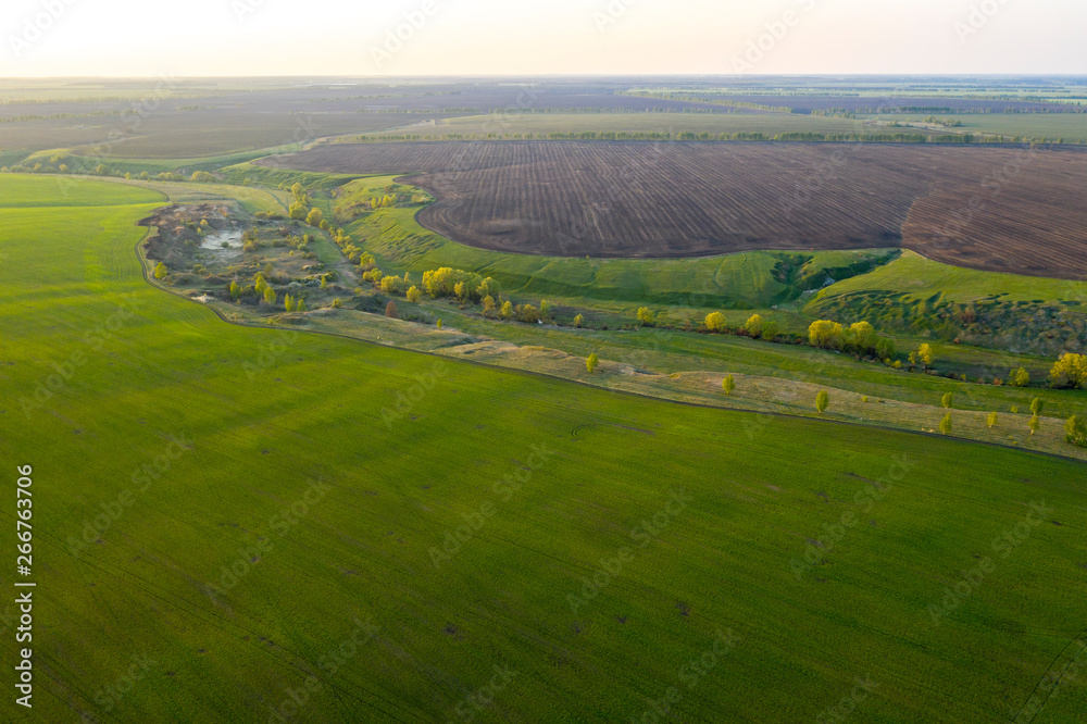 Spring fields, meadows, ravines at sunset from the quadrocopter