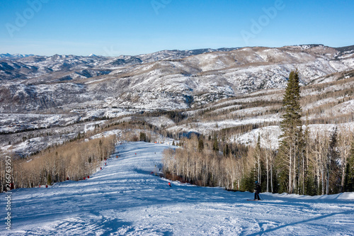 View of the mountains and slopes of Steamboat Springs, in the Rocky Mountains of Colorado, lined by Pine and Aspen trees. 