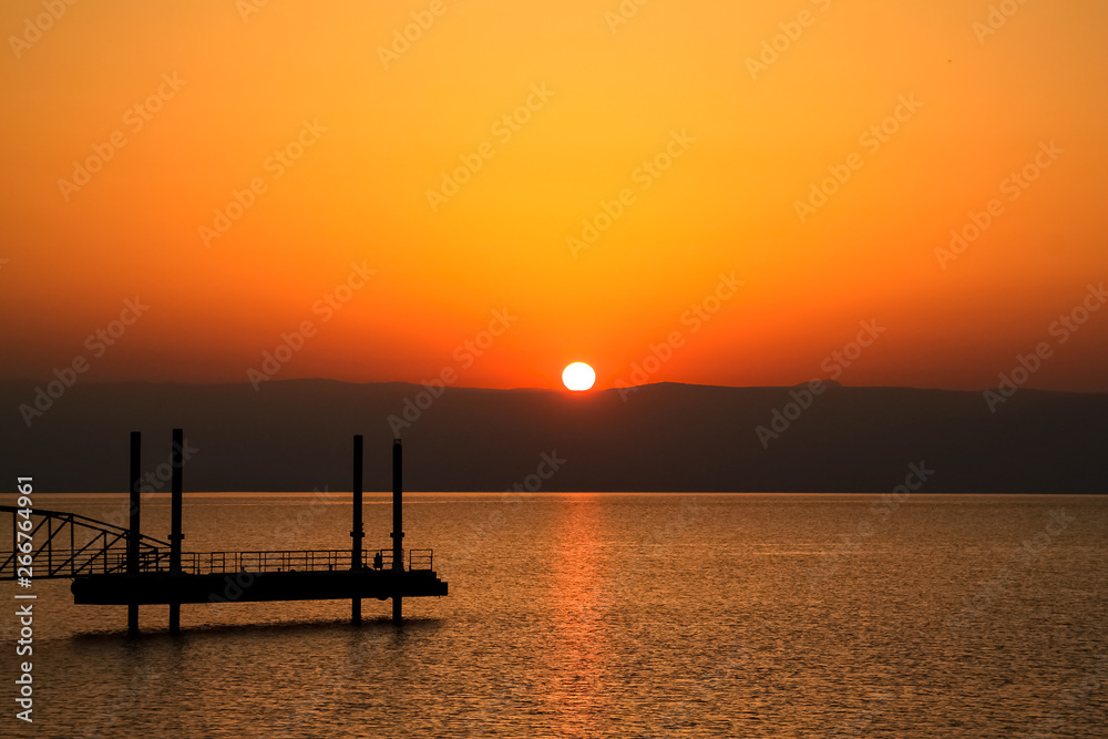 Sun rises over mountains alongside the Sea of Galilee