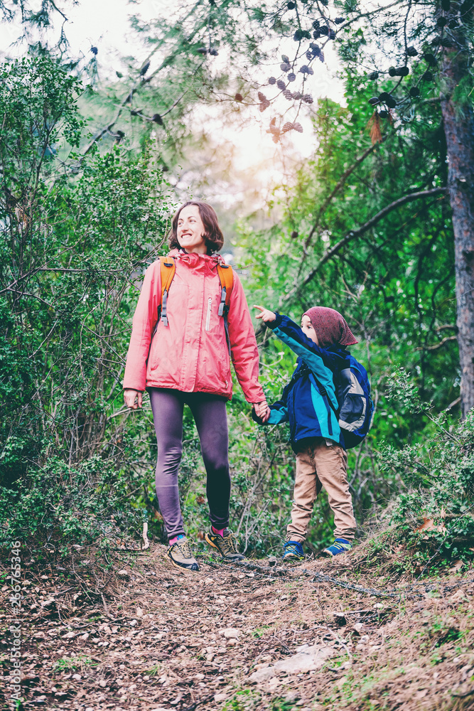 A woman walks with her son through the forest. A woman walks with her son through the forest.
