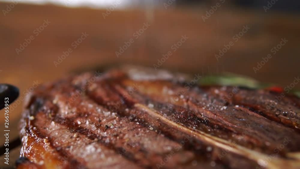 Hot juicy t-bone steak is served at the restaurant on a cutting Board Hot juicy t-bone steak is served at the restaurant on a cutting Board