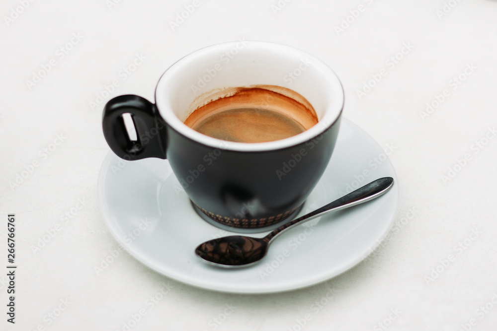 Green coffee cup with small spoon on a plate on a white background – Hot tasty and sweet drink with foam served in a mug for breakfast - Fresh black beverage used for energy Green coffee cup with small spoon on a plate on a white background – Hot tasty and sweet drink with foam served in a mug for breakfast - Fresh black beverage used for energy