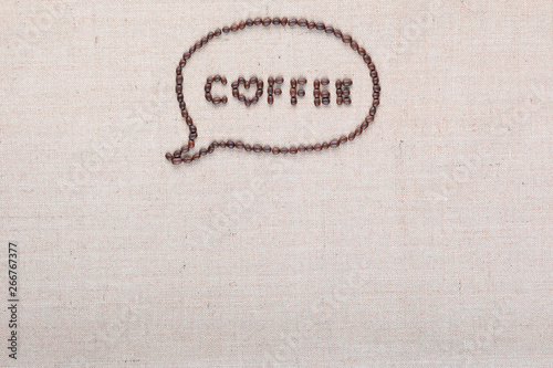 Coffee letters in talk cloud from coffee beans on linen canvas arranged on top center.