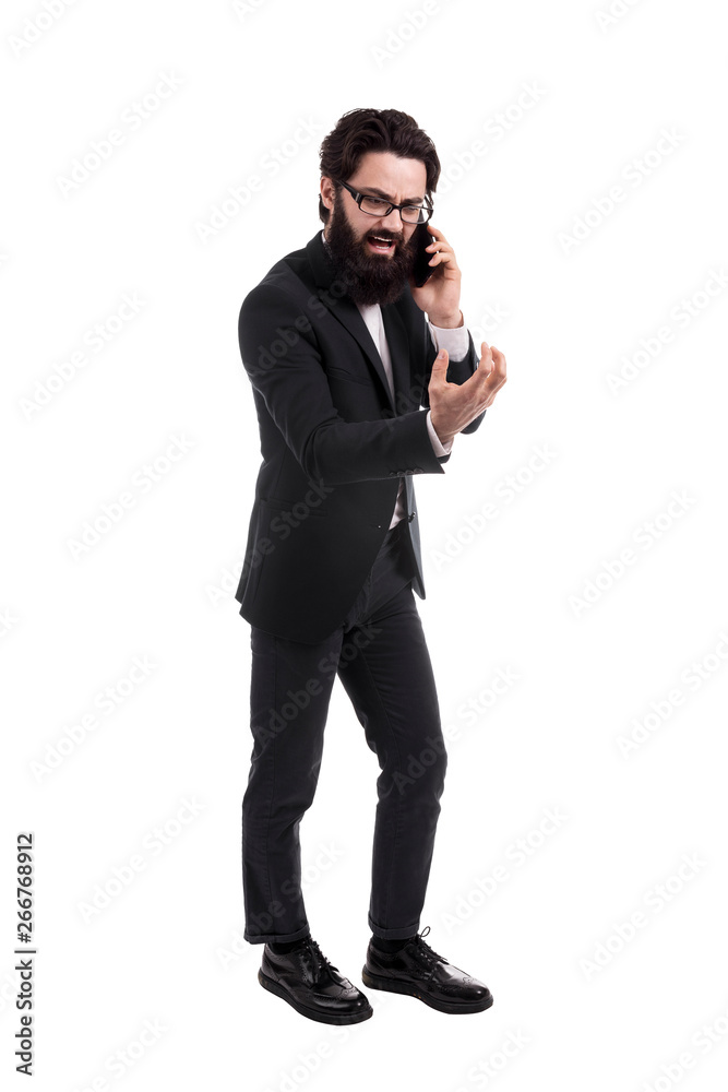 Naklejka premium Full length portrait of a aggressive bearded businessman swears on the smartphone, isolated on white background