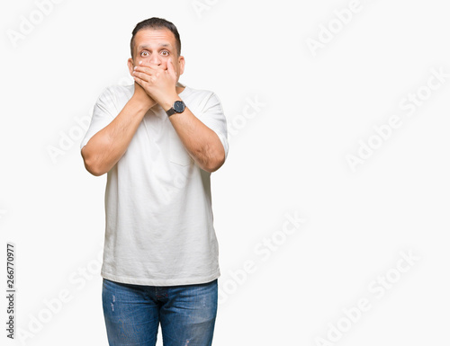 Middle age arab man wearig white t-shirt over isolated background shocked covering mouth with hands for mistake. Secret concept.