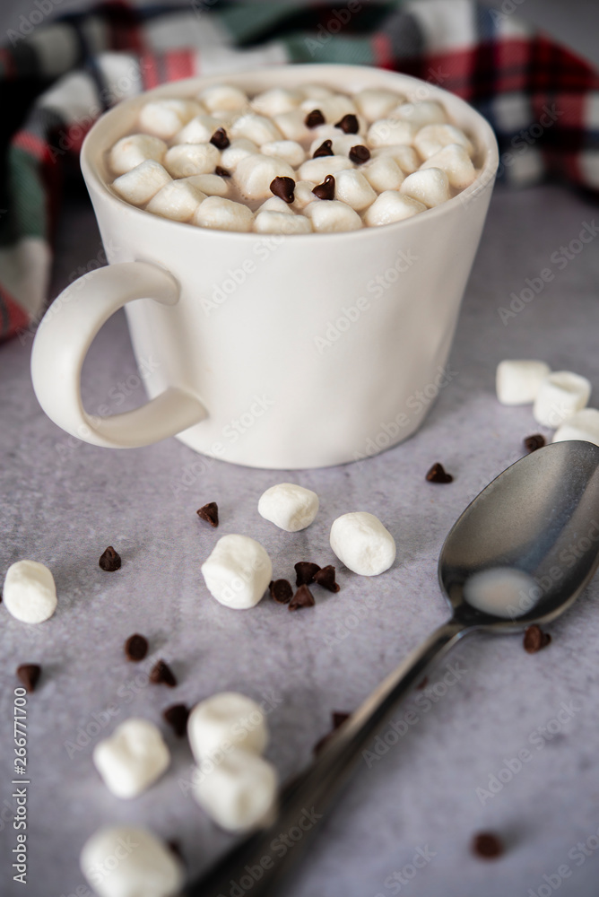 Hot cocoa in white mug with silver spoon and colorful napkin Hot cocoa in white mug with silver spoon and colorful napkin