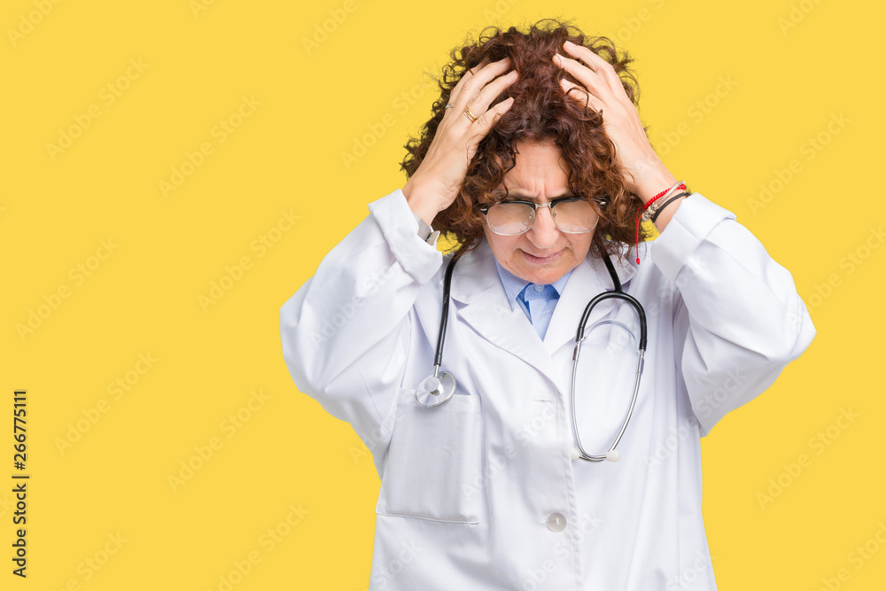 Middle ager senior doctor woman over isolated background suffering from headache desperate and stressed because pain and migraine. Hands on head. Middle ager senior doctor woman over isolated background suffering from headache desperate and stressed because pain and migraine. Hands on head.