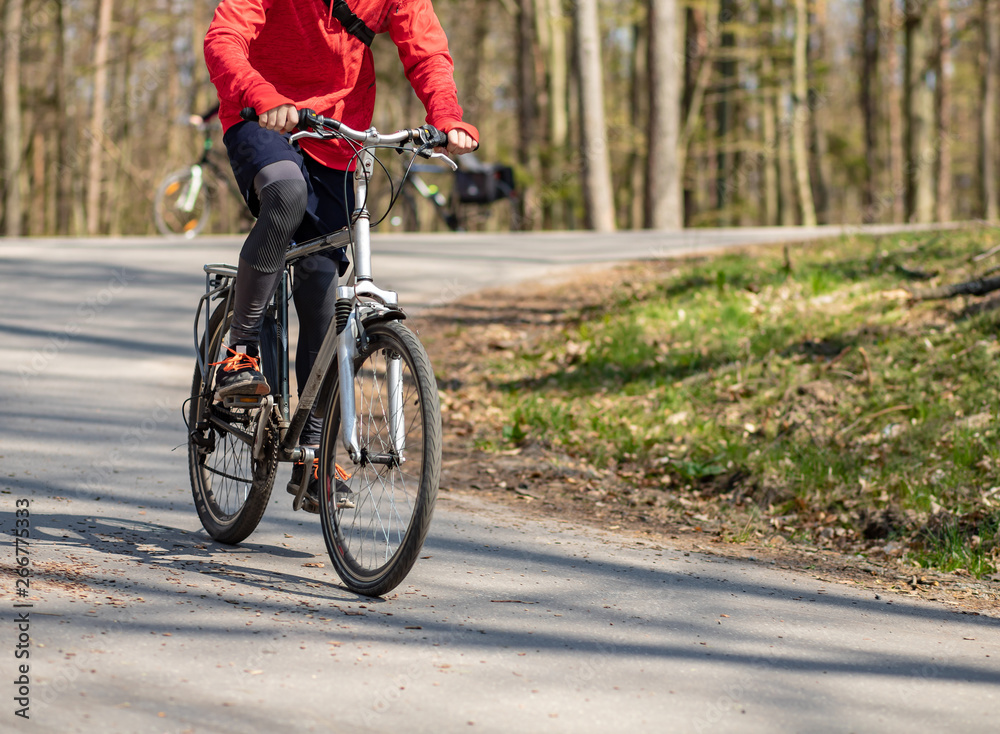 Bicyclist driving down the hill in the forest.