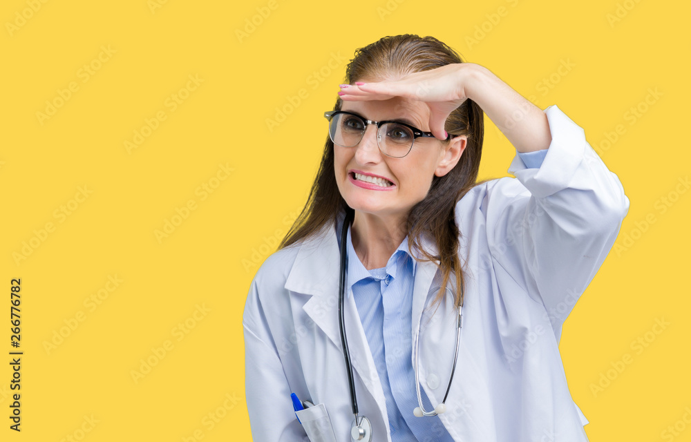 Middle age mature doctor woman wearing medical coat over isolated background very happy and smiling looking far away with hand over head. Searching concept.