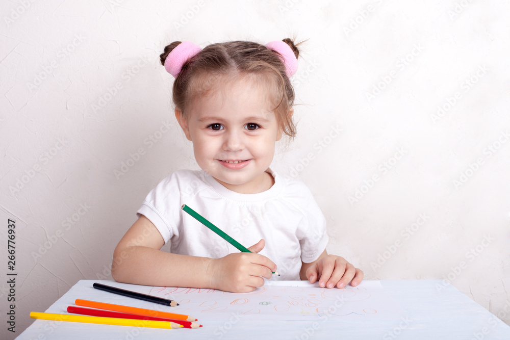 The girl draws in colored pencils The girl draws in colored pencils
