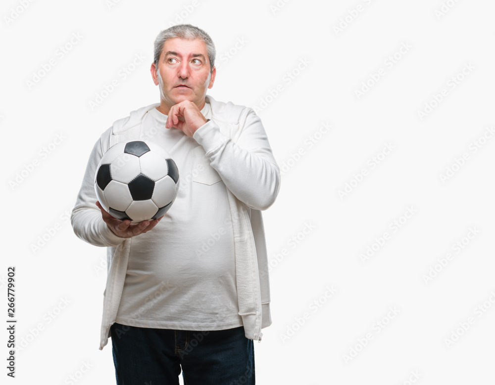 Handsome senior man holding soccer football ball over isolated background serious face thinking about question, very confused idea Handsome senior man holding soccer football ball over isolated background serious face thinking about question, very confused idea