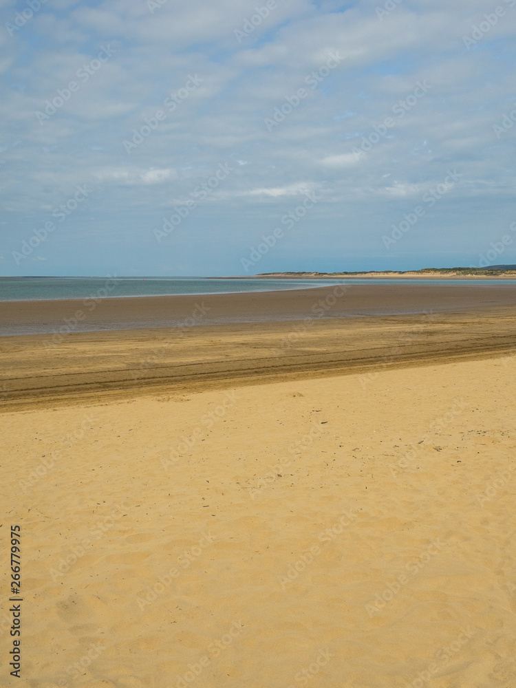 Golden sandy beach . blue sea and sky background with clouds at Instow in North Devon , England