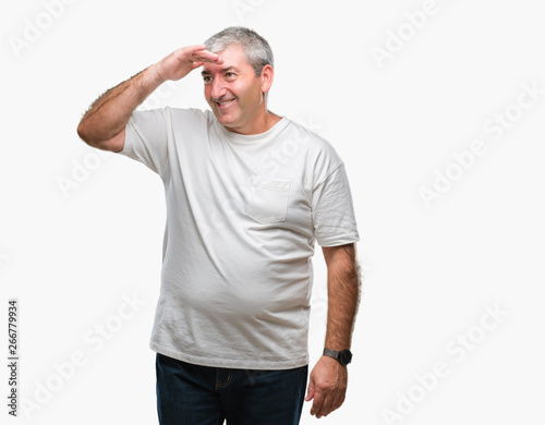 Handsome senior man over isolated background very happy and smiling looking far away with hand over head. Searching concept.