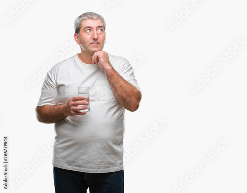 Handsome senior man drinking glass of water over isolated background serious face thinking about question, very confused idea