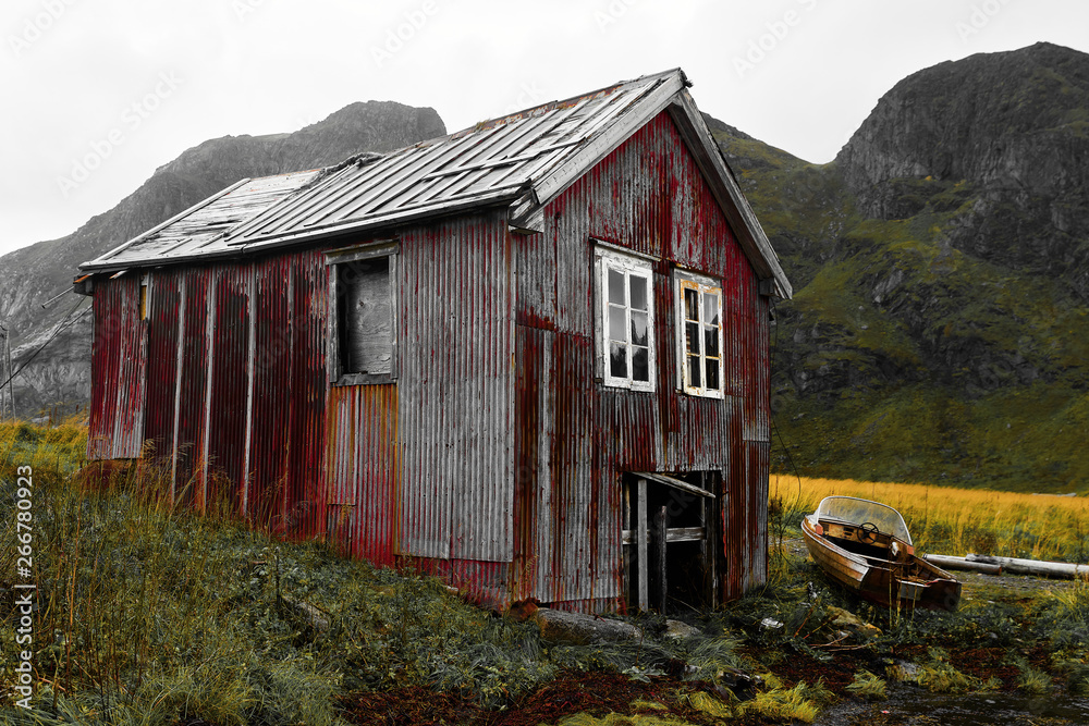 Fototapeta premium Old damaged and weathered wooden boat house at the coast of Vinstad on Lofoten Islands in Norway