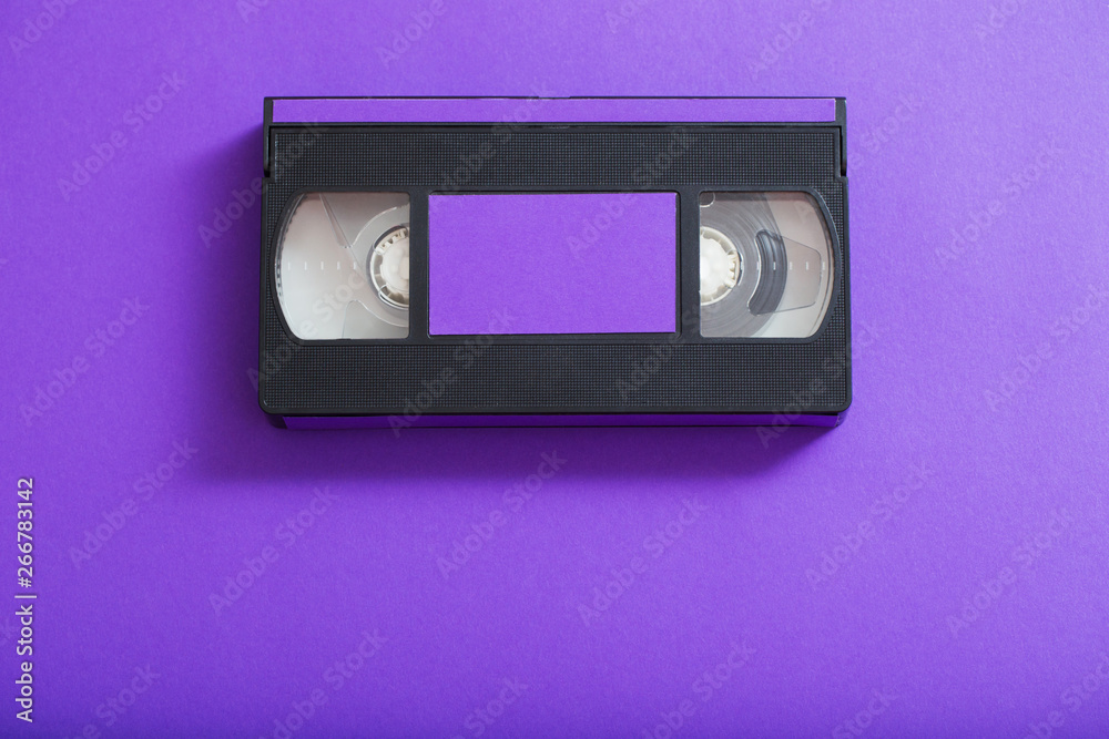 Video cassette on violet background.