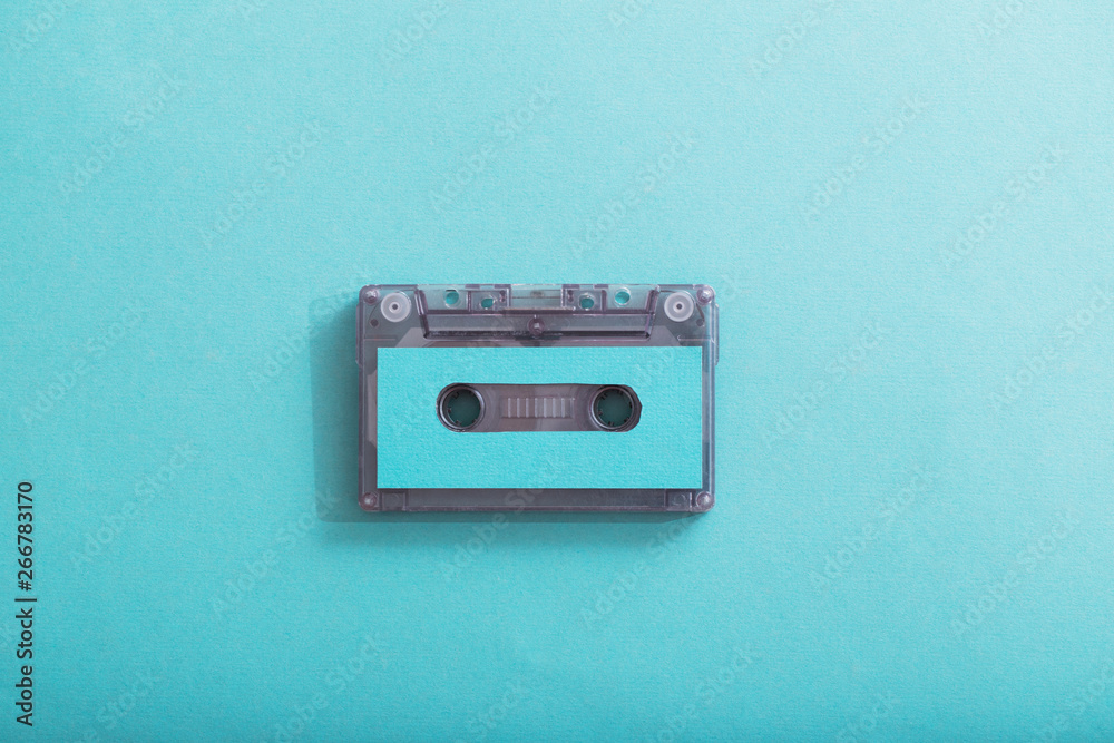 Fototapeta premium Old plastic cassette on green background. Retro music concept