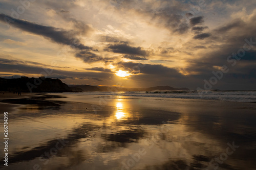 sunset on the beach of Atxabiribil  Sopelana  vizcaya. The sun is reflected on the seashore
