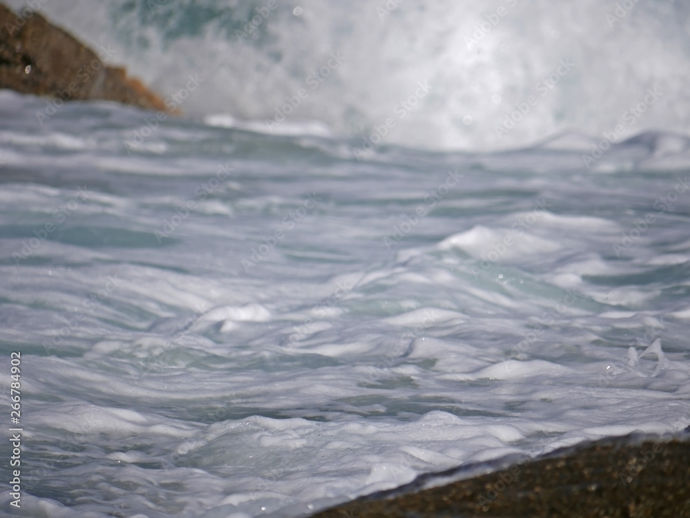 Fototapeta premium Waves crashing against the rock