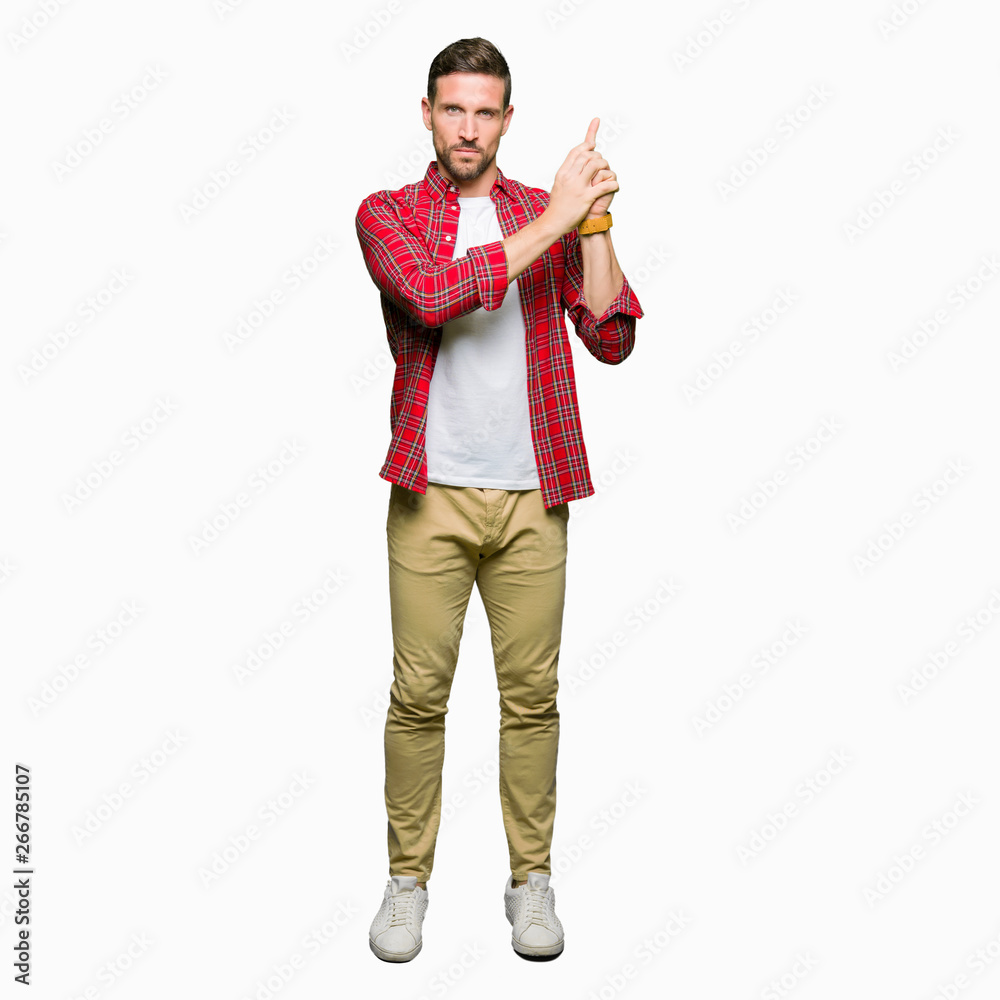 Handsome man wearing casual shirt Holding symbolic gun with hand gesture, playing killing shooting weapons, angry face Handsome man wearing casual shirt Holding symbolic gun with hand gesture, playing killing shooting weapons, angry face