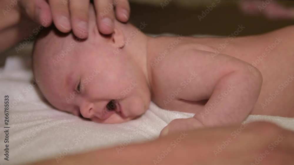The father gently strokes the newborn child who lies on his stomach. The father gently strokes the newborn child who lies on his stomach.
