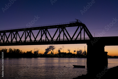 Railway bridge with chemical plant on the background in Sliedrecht, the Netherlands. During sundown. Blue yellow sky. photo