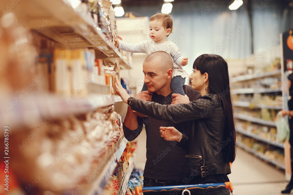 Obraz premium Mother with little daughter. The family makes purchases in the store. Father with kid and wife